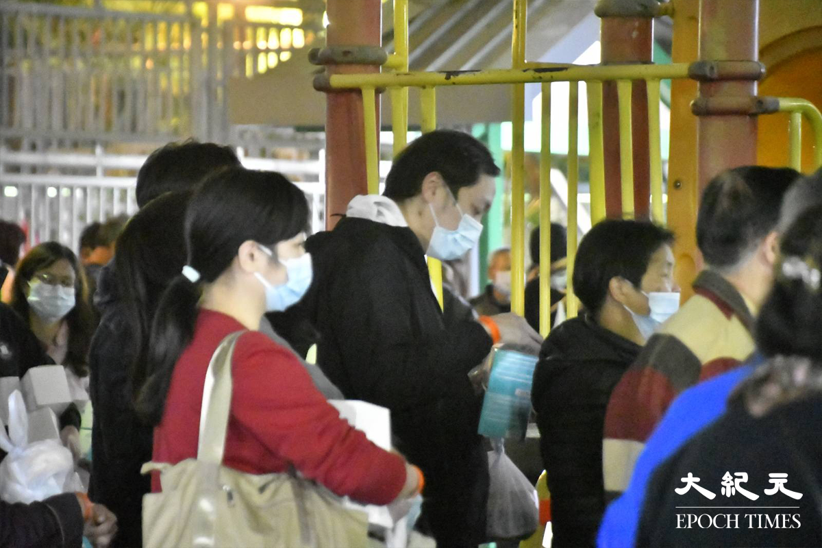 晚上9時，已完成檢測的居民，於居和樓對開一個休憩公園排隊等候返回家中。（麥碧／大紀元）