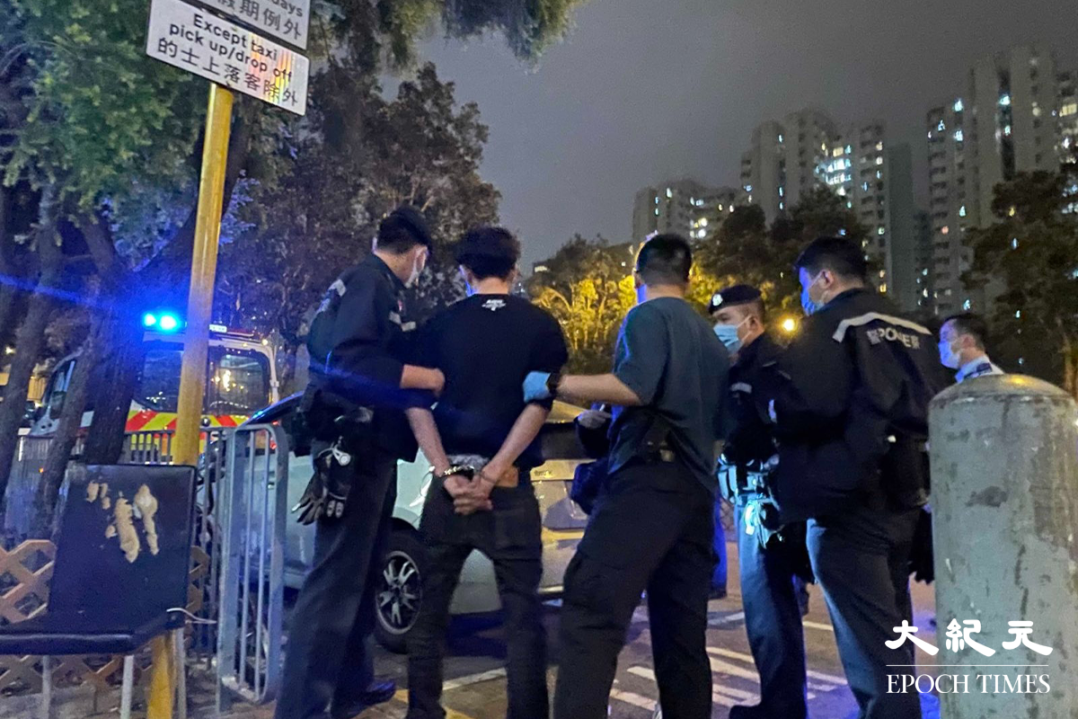 警方將涉嫌販毒的疑犯，押返私家車旁協助搜查。（卓相如／大紀元）