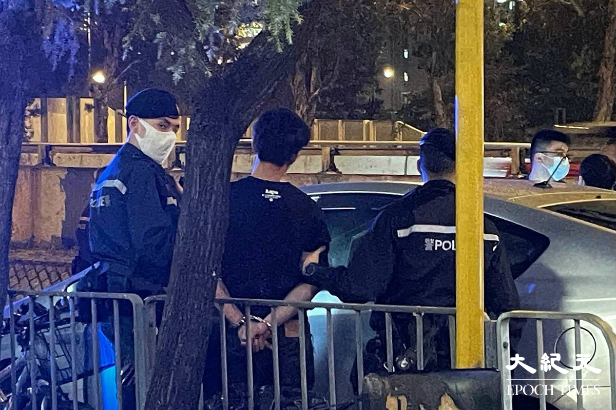 警方將涉嫌販毒的疑犯，押返私家車旁協助搜查。（卓相如／大紀元）
