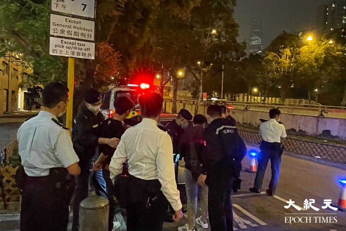 警方將涉嫌販毒的疑犯，押返私家車旁協助搜查。（卓相如／大紀元）