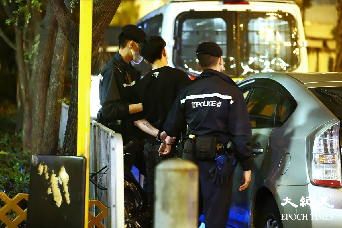 警方將涉嫌販毒的疑犯，押返私家車旁協助搜查。（譚嘉嘉／大紀元）