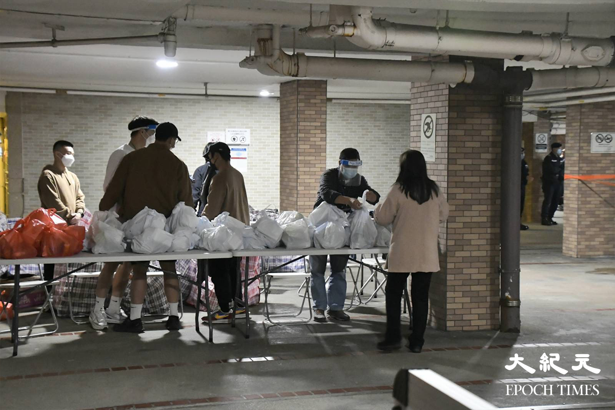 百老匯街72及74號居民完成檢測後領取物資，等候職員安排返回家中。（麥碧／大紀元）