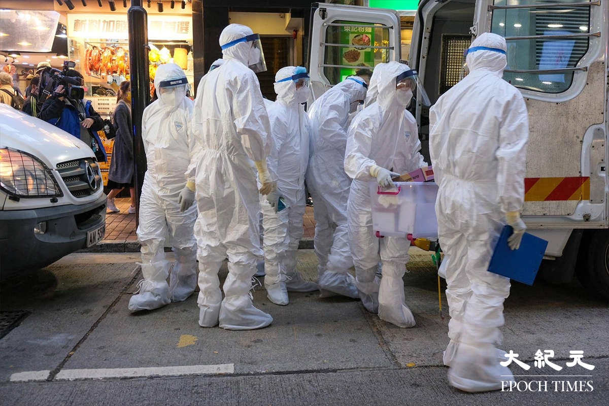 穿著全套白色保護裝備的漁護署工作人員，於下午5時30分抵達銅鑼灣渣甸街涉事寵物店 Little Boss 外，警方派出警員在場戒備。（朱寶生／大紀元）