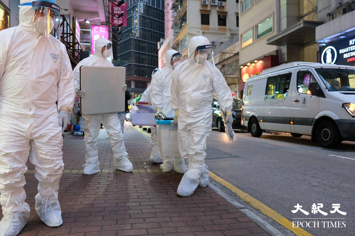 穿著全套白色保護裝備的漁護署工作人員，於下午5時30分抵達銅鑼灣渣甸街涉事寵物店 Little Boss 外，警方派出警員在場戒備。（朱寶生／大紀元）