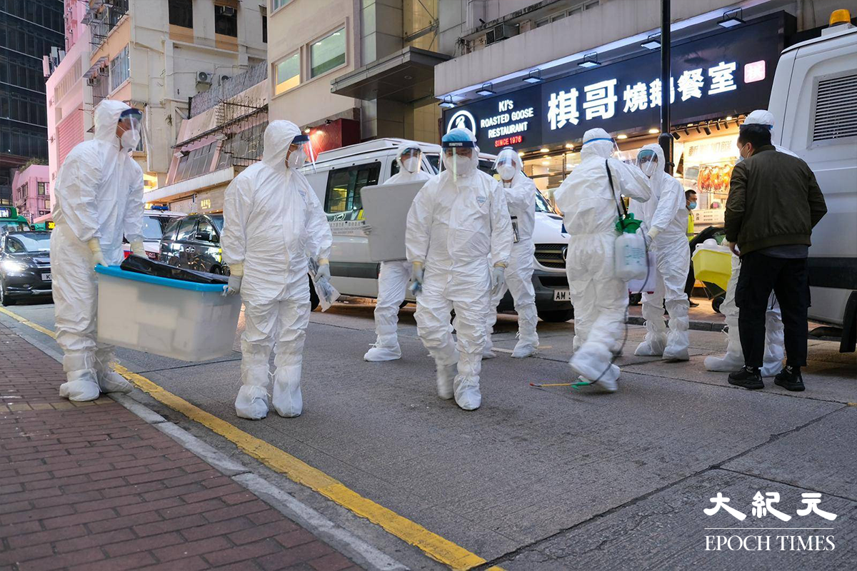 穿著全套白色保護裝備的漁護署工作人員，於下午5時30分抵達銅鑼灣渣甸街涉事寵物店 Little Boss 外，警方派出警員在場戒備。（朱寶生／大紀元）