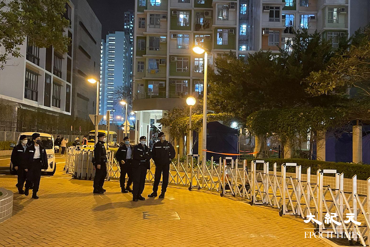 政府晚上7時54分刊登憲報後，大批工作人員進駐長沙灣邨長欣樓對開，有部分更已換上全套保護衣，為稍後居民強檢準備。（卓相如／大紀元）