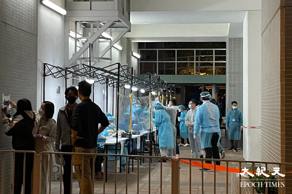 政府晚上7時54分刊登憲報後，大批工作人員進駐長沙灣邨長欣樓對開，有部分更已換上全套保護衣，為稍後居民強檢準備。（卓相如／大紀元）