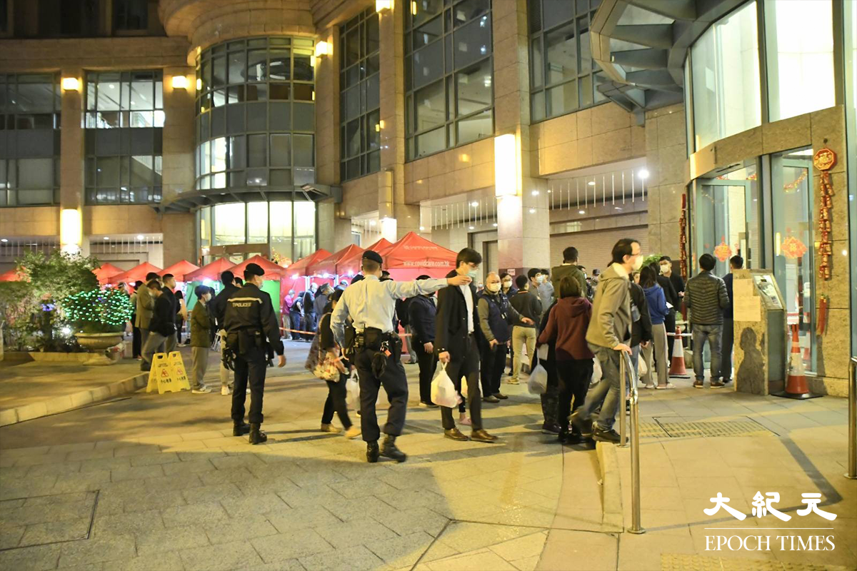 荃灣名逸居電梯大堂外，警員在場指揮已接受檢測的居民排隊返回家中。（麥碧／大紀元）
