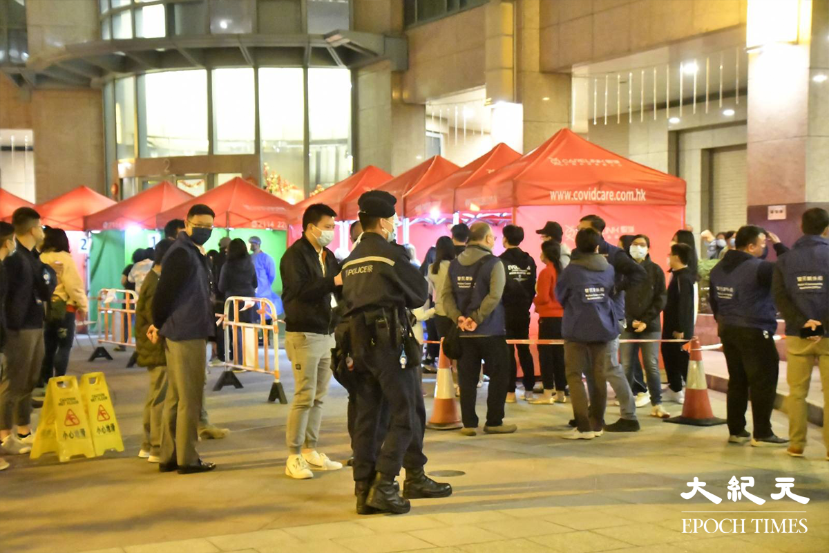 荃灣名逸居電梯大堂外，警員在場指揮已接受檢測的居民排隊返回家中。（麥碧／大紀元）