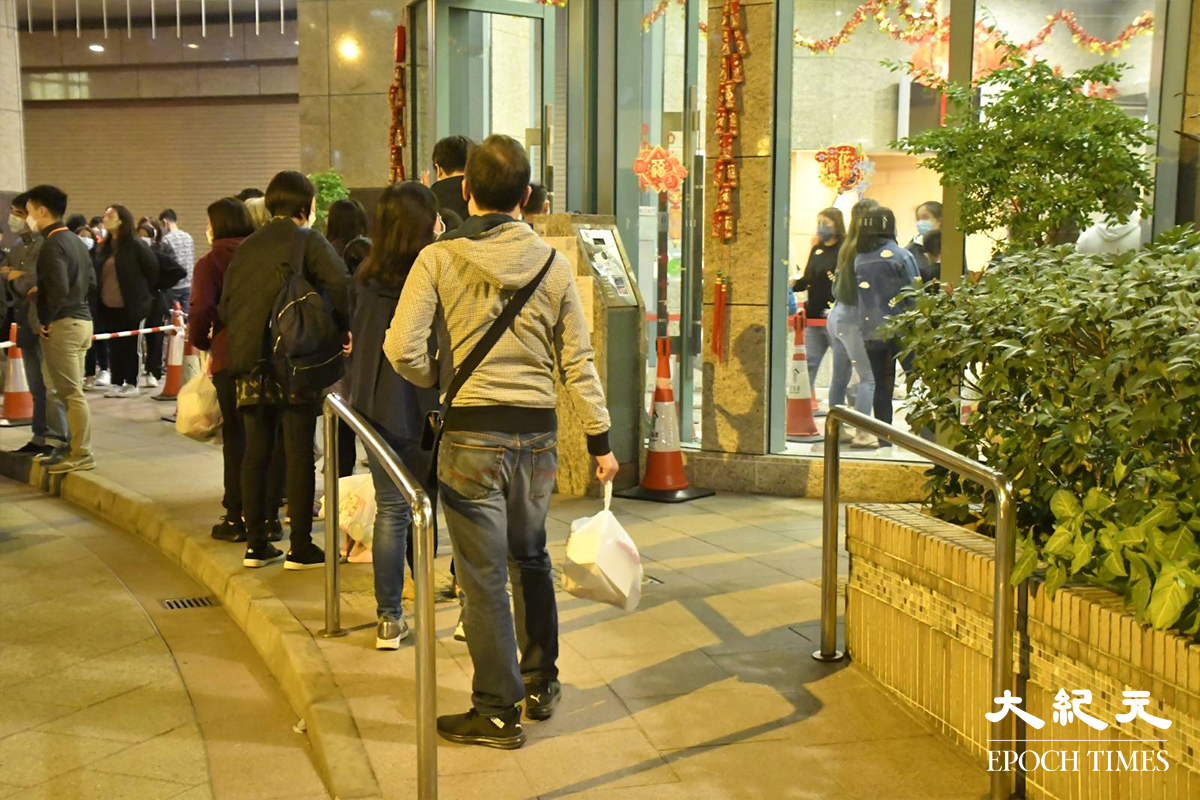 荃灣名逸居電梯大堂外，警員在場指揮已接受檢測的居民排隊返回家中。（麥碧／大紀元）