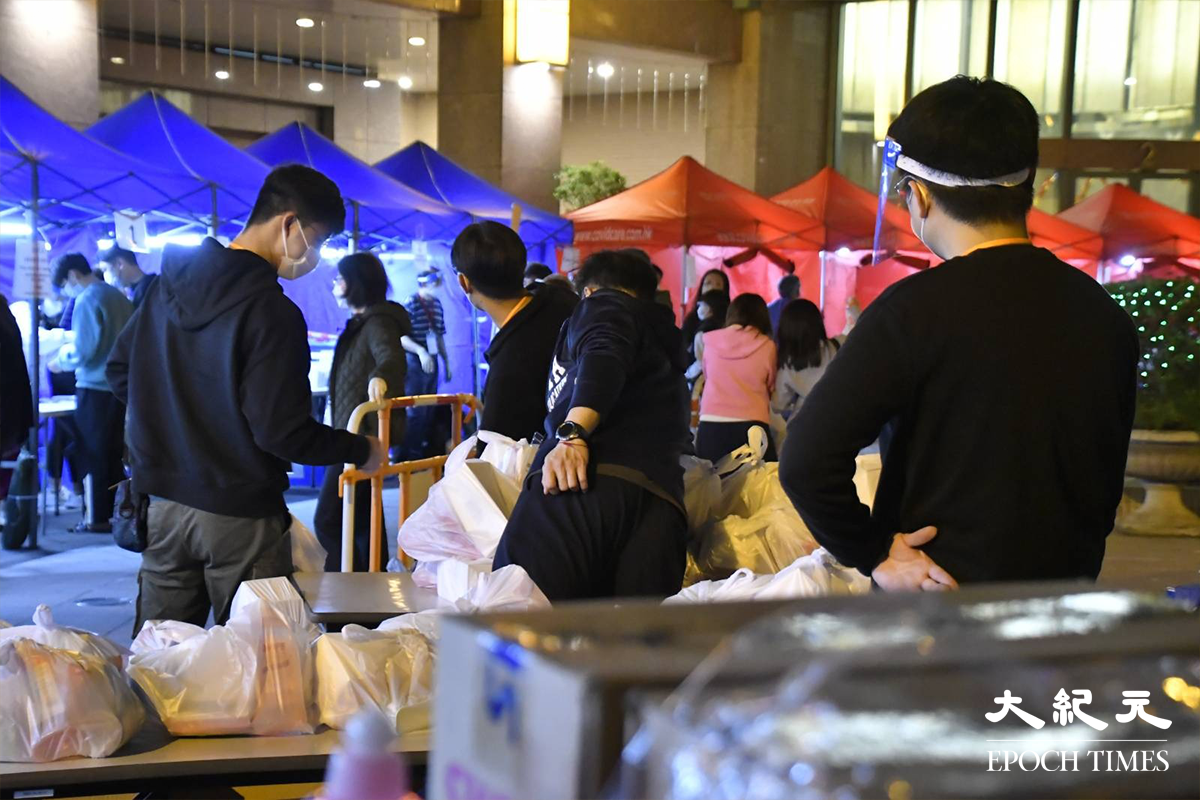 荃灣名逸居第1座居民於紅色帳篷接受檢測後，被安排到藍色帳篷登記，之後再到旁邊領取物資袋返回家中。（麥碧／大紀元）