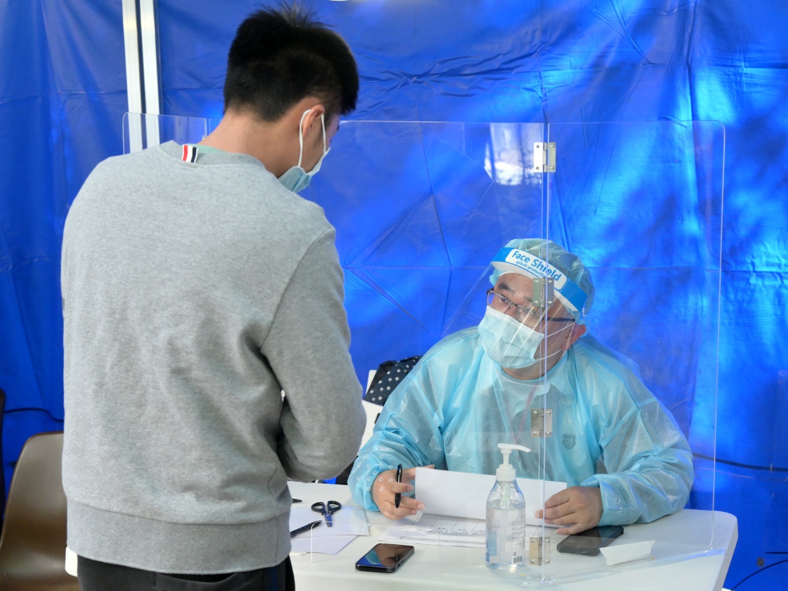 工作人員在「受限區域」內進行執法行動，檢查受限人士是否已接受強制檢測。（政府新聞處）