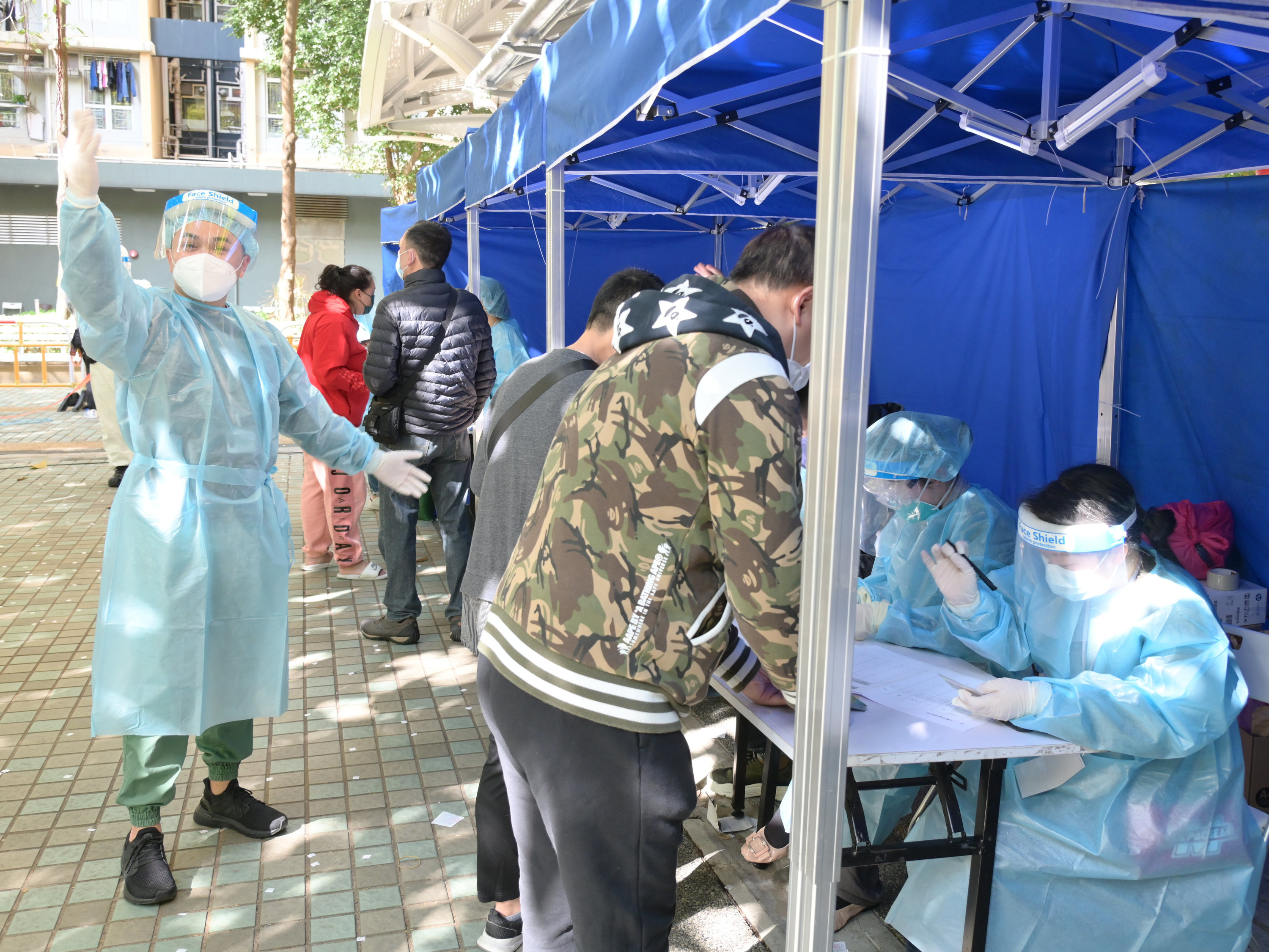 工作人員在「受限區域」內進行執法行動，檢查受限人士是否已接受強制檢測。（政府新聞處）