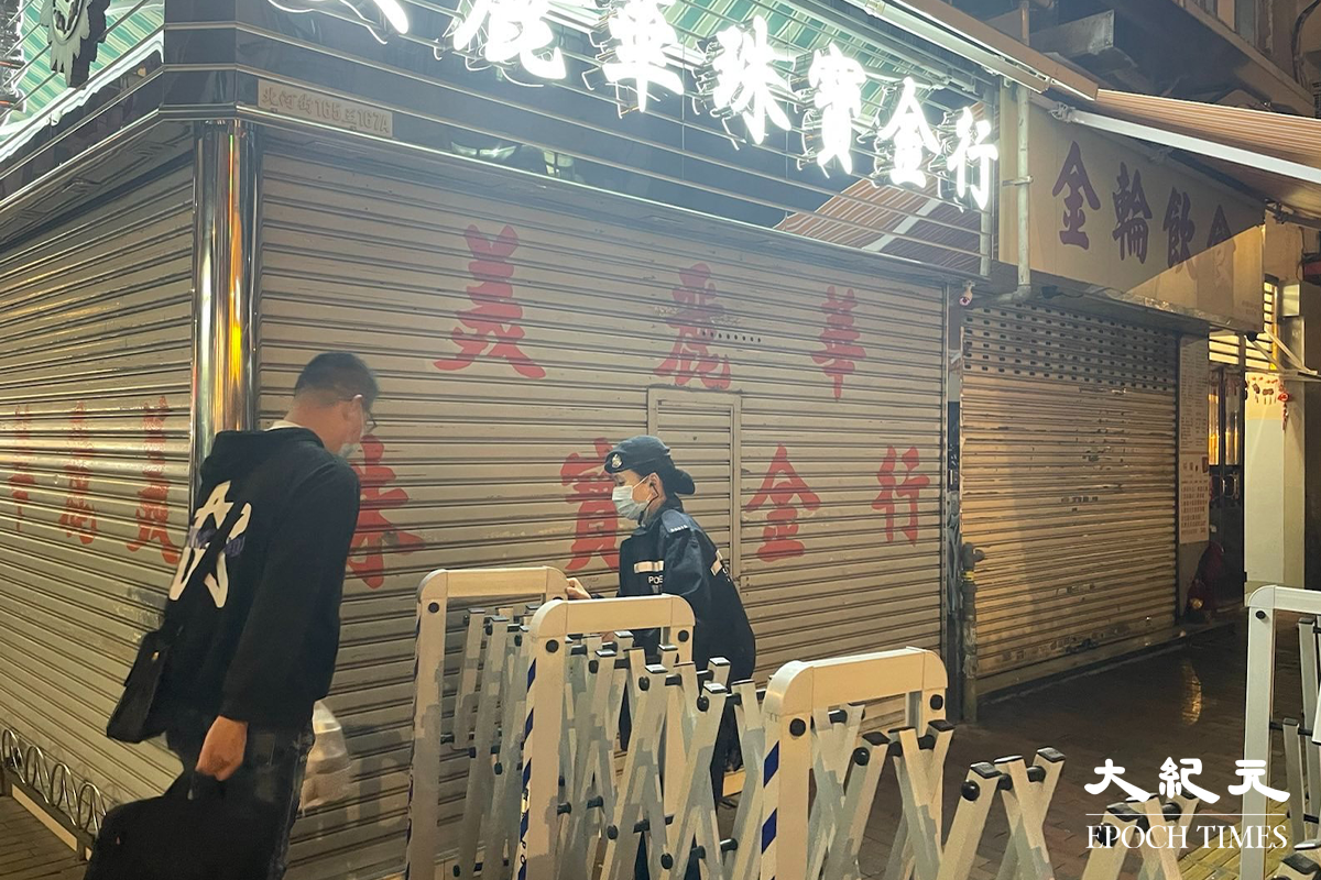 政府於晚上7時30分刊登憲報，將深水埗北河街169-171號慶豐大廈圍封後，大批警員隨即在受限區域外設置封鎖線，限制市民出入。（卓相如／大紀元）