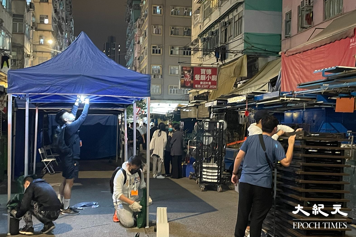 政府於晚上7時30分刊登憲報，將深水埗北河街169-171號慶豐大廈圍封後，大批警員隨即在受限區域外設置封鎖線，限制市民出入。（卓相如／大紀元）