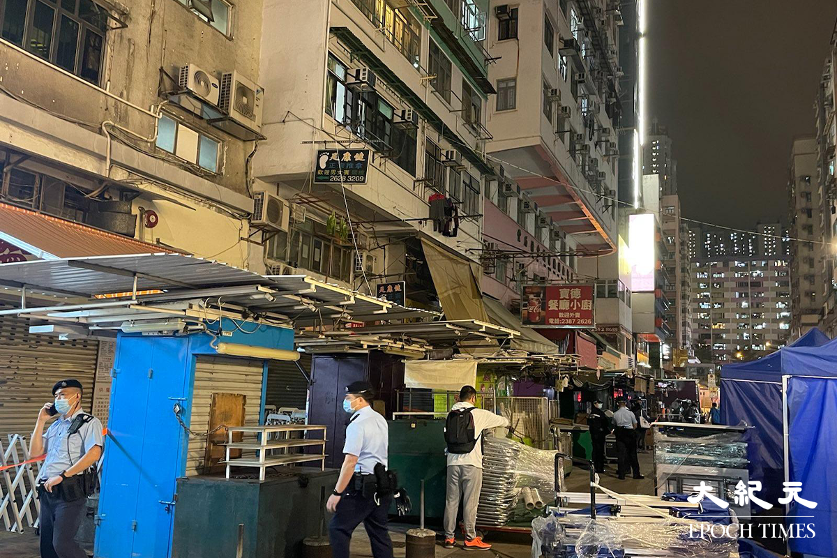 政府於晚上7時30分刊登憲報，將深水埗北河街169-171號慶豐大廈圍封後，大批警員隨即在受限區域外設置封鎖線，限制市民出入。（卓相如／大紀元）