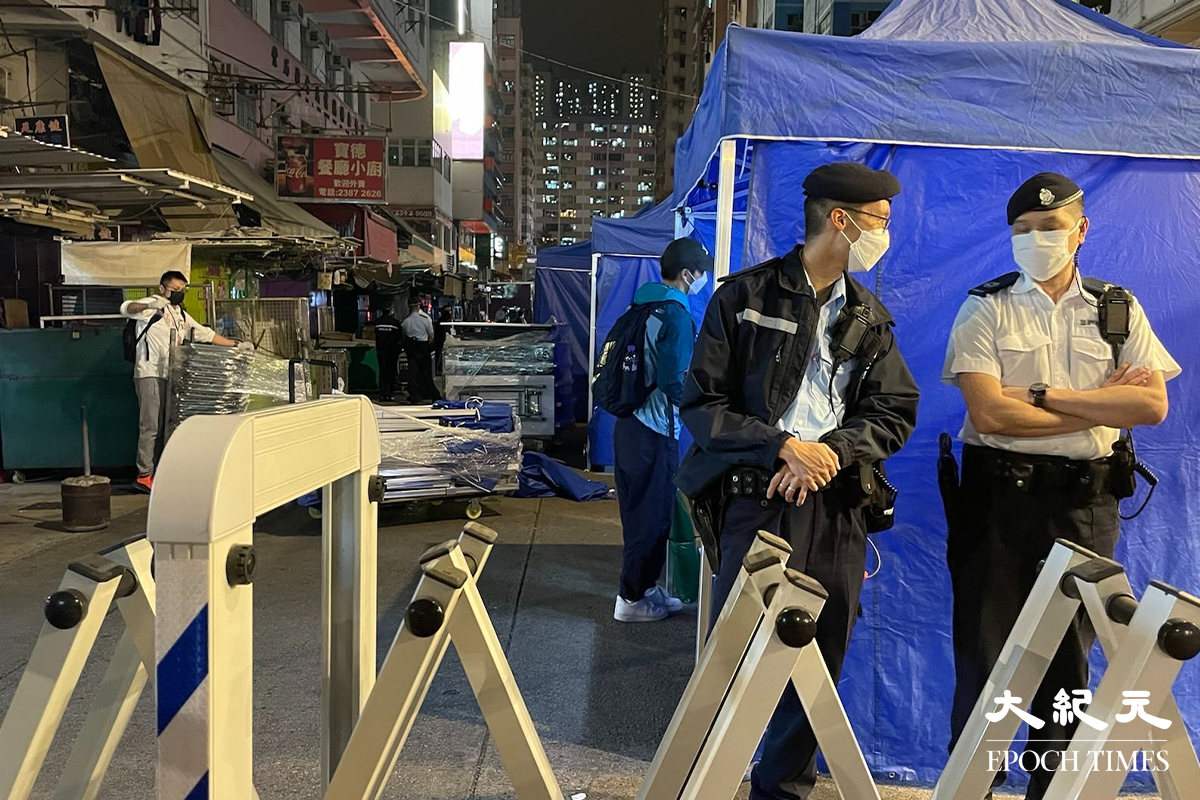 政府於晚上7時30分刊登憲報，將深水埗北河街169-171號慶豐大廈圍封後，大批警員隨即在受限區域外設置封鎖線，限制市民出入。（卓相如／大紀元）