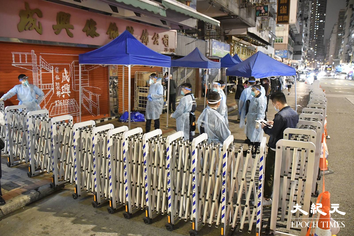 晚上8時20分，穿著全套保護裝備的警員拿著橙帶(封鎖線)在惠珍樓外戒備。（麥碧／大紀元）