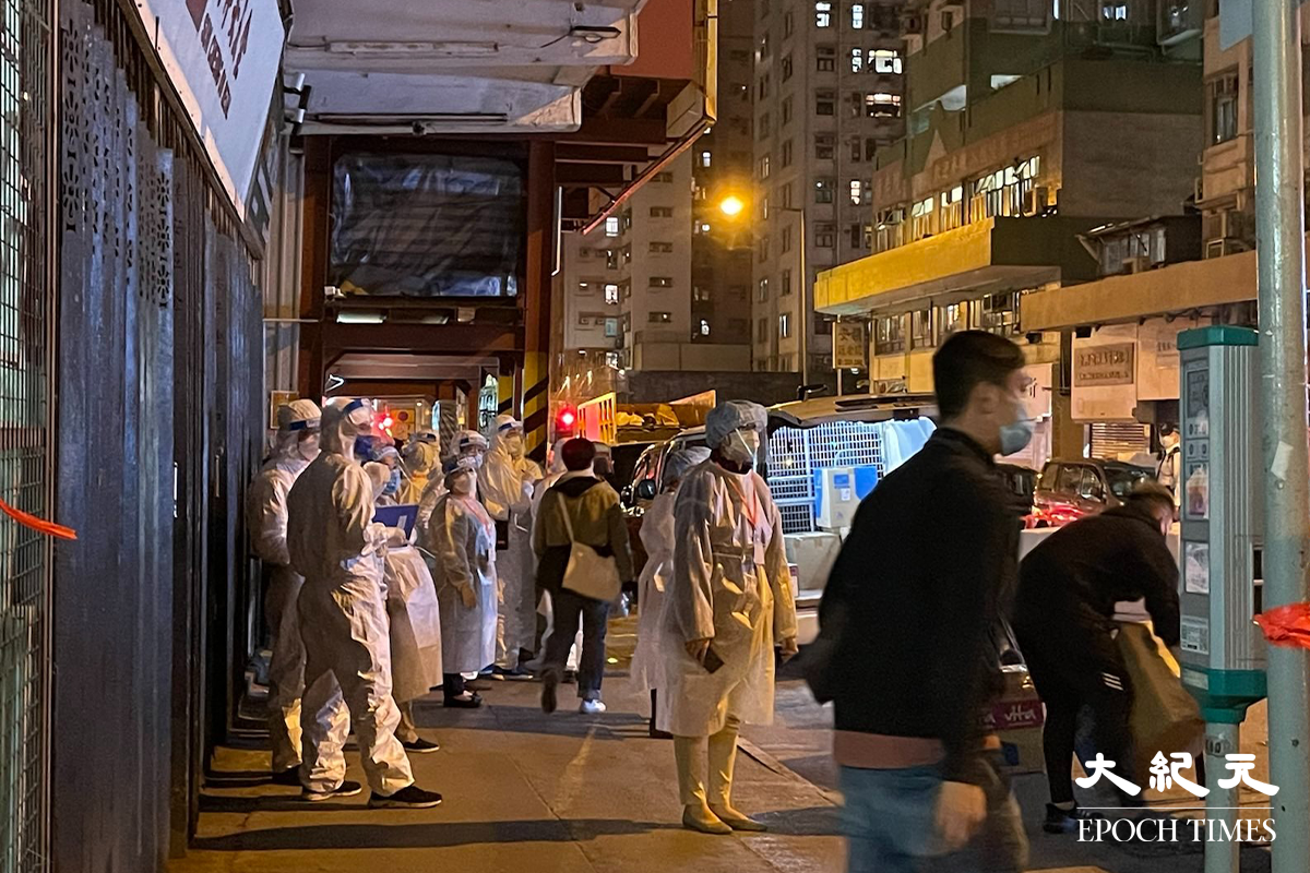 晚上8時30分政府刊登憲報，將土瓜灣鴻光街21、23、25，27、29、31、33及35號指列為受限區域，隨即大批穿著全套保護裝備的工作人員趕抵。（卓相如／大紀元）