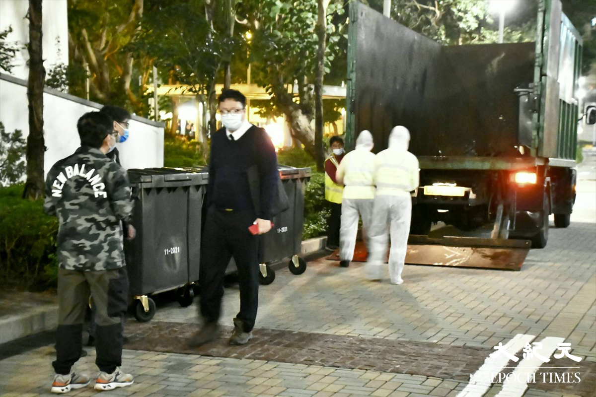 晚上7時10分，穿著全套白色保護裝備的工作人員，已在藍天海岸A座外準備。（麥碧／大紀元）