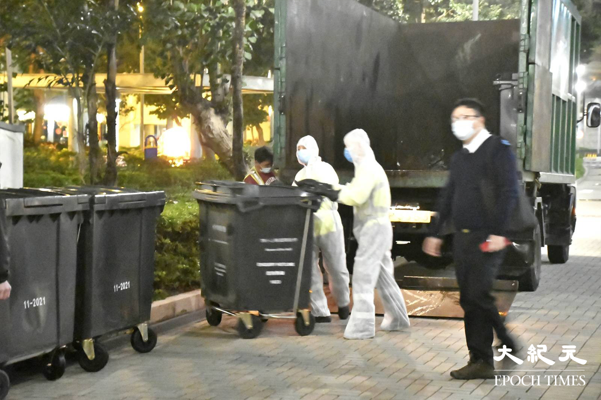晚上7時10分，穿著全套白色保護裝備的工作人員，已在藍天海岸A座外準備。（麥碧／大紀元）