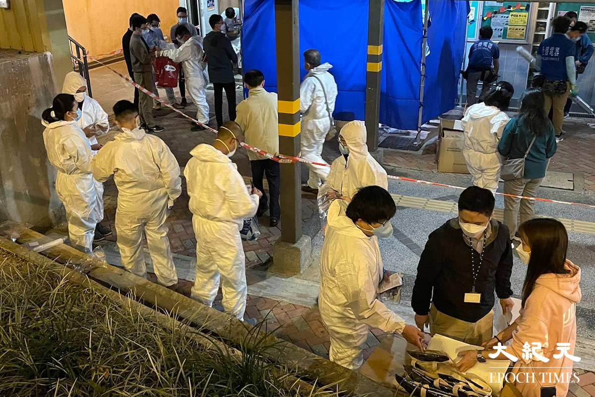晚上8時20分，多名穿著全套保護裝備的工作人員，在彩雲邨長波樓外準備。（卓相如／大紀元）
