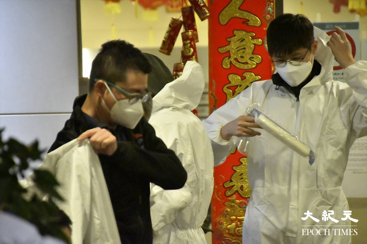 晚上8時32分，警方在新葵芳花園C座大廈外置封鎖線，代表正式將該區指列為受限區域。在場工作人員隨即在大廈門外，穿上全套白色保護衣。（麥碧／大紀元）