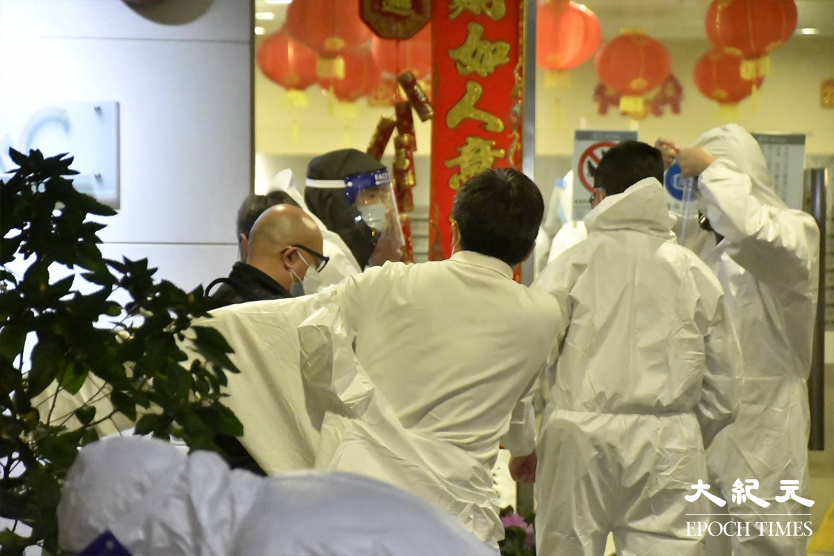 晚上8時32分，警方在新葵芳花園C座大廈外置封鎖線，代表正式將該區指列為受限區域。在場工作人員隨即在大廈門外，穿上全套白色保護衣。（麥碧／大紀元）