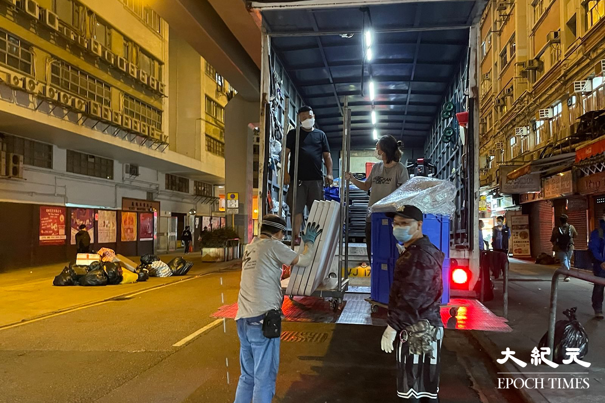 晚上7時35分，大批工作人員運送物資道隆基大樓D座大廈外。（卓相如／大紀元）