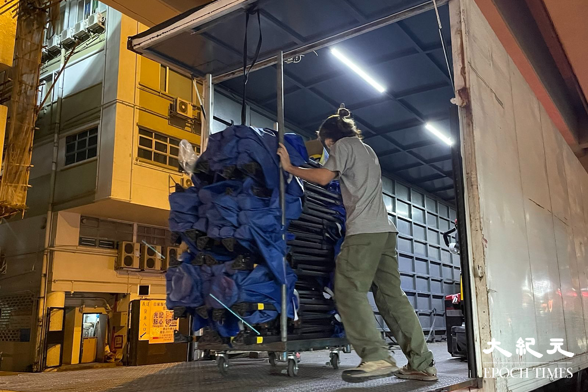 晚上7時35分，大批工作人員運送物資道隆基大樓D座大廈外。（卓相如／大紀元）