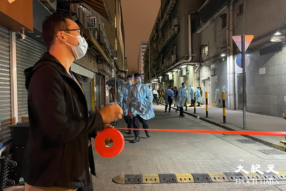 晚上7時35分，大批工作人員運送物資道隆基大樓D座大廈外。（卓相如／大紀元）