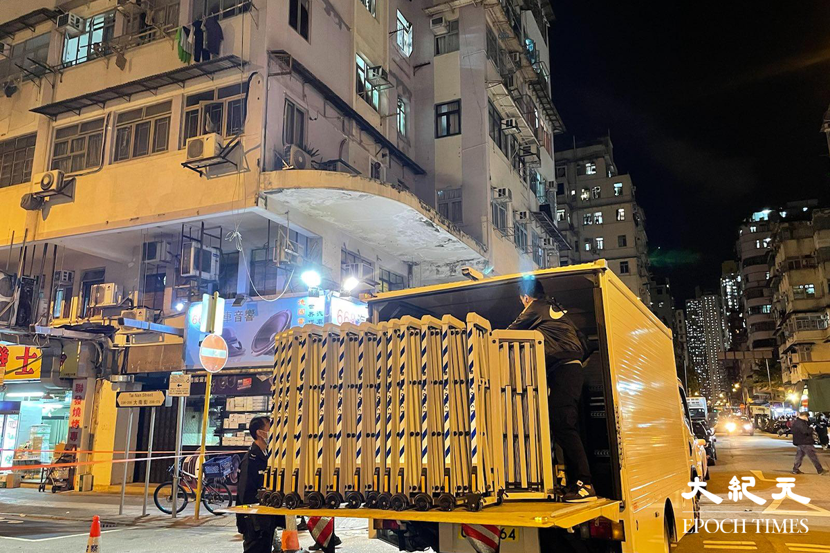 政府晚上7時55分刊登憲報，將大南街多幢樓宇資料為受限區域後，工作人員開始在受限區域內準備。（卓相如／大紀元）
