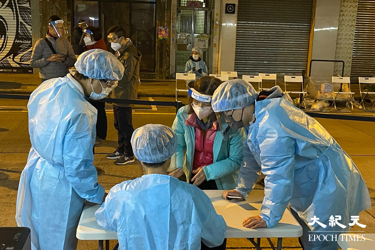 晚上10時許，環境局常任秘書長兼環境保護署署長謝小華(藍色外套者)，抵達深水埗封區現場視察。（卓相如／大紀元）