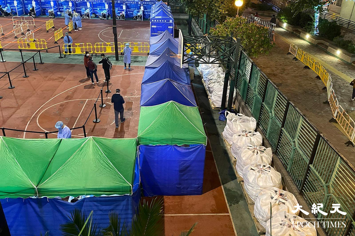 政府晚上7時30分刊登憲報，將朗朗屏邨鵲屏樓、鳳屏樓指列為受限區域後。晚上約8時30分，鵲屏樓及鳳屏樓對開的一個籃球場，已改成為一個臨時檢測站。晚上約9時，陸續有受限區域內居民到檢測站排隊等候檢測。（卓相如／大紀元）