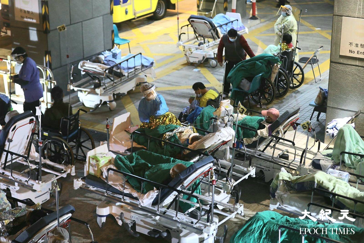 昨日（15日）晚上8時左右，記者目測約有三十名病人，於明愛醫院急症室外臥在病床上等入院，據了解這批人全是初步確診者。而位於明愛醫院另一邊位置，約有四十多人在臨時帳篷內等候檢測結果。（胡凱欣／大紀元）