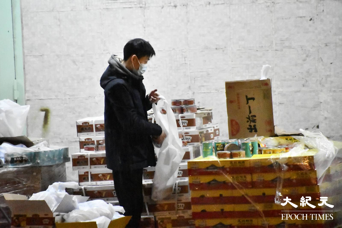 傍晚6時許，工作人員在南昌邨昌逸閣外，將稍後分發給居民的物資分類包裝。（麥碧／大紀元）