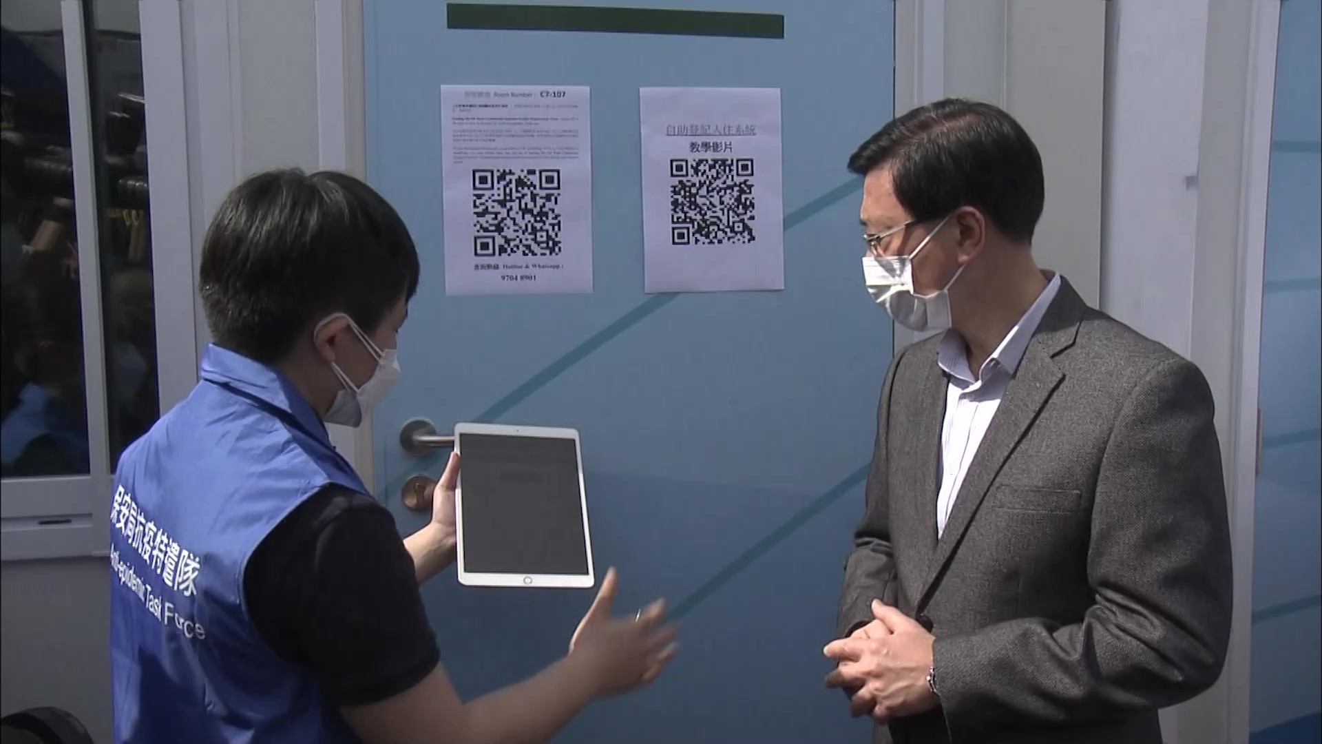 保安局抗疫特遣隊向李家超介紹及示範電子自助登記服務。（政府新聞處影片截圖）