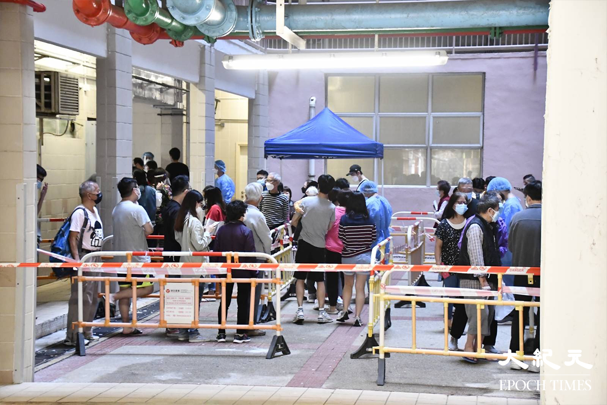 下午5時許，近百名榮園樓住戶在地下檢測站，排隊等候強制檢測。（麥碧／大紀元）