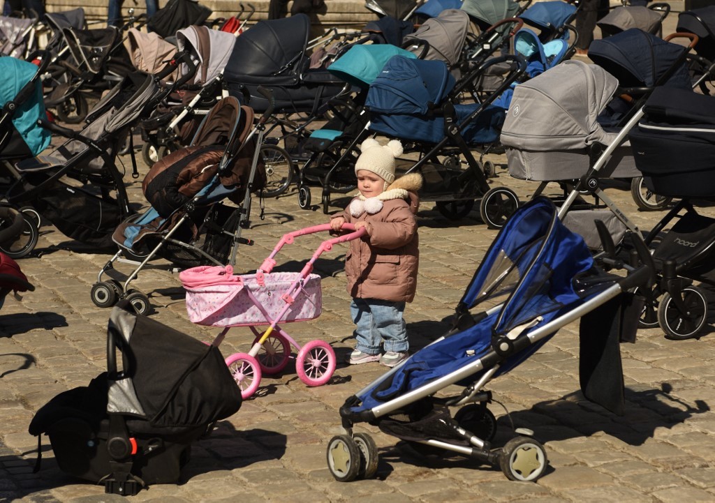 2022年3月18日，利沃夫（Lviv）市民在市政廳外放置了109部空嬰兒車和嬰兒籃，以代表俄羅斯入侵烏克蘭期間遇難的兒童數目。（Yuriy Dyachyshyn / AFP）