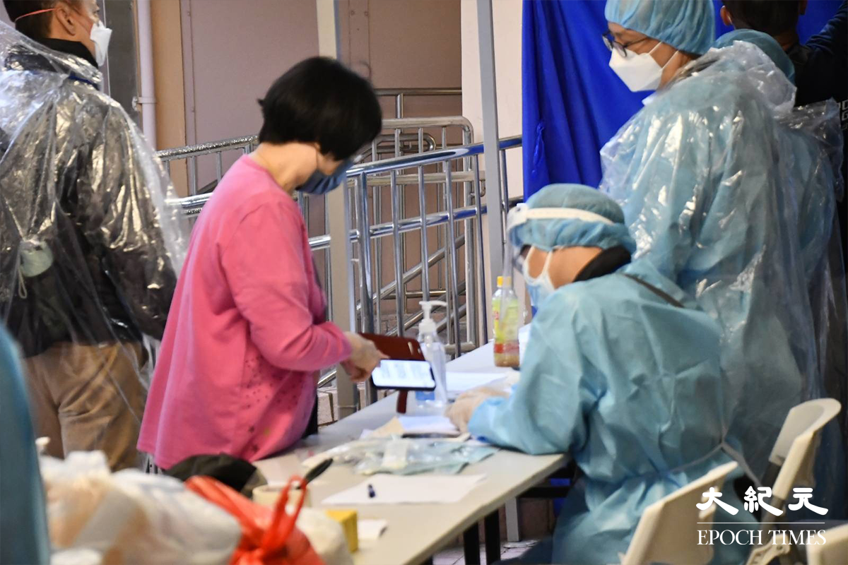 當明彩虹邨翠瓊樓住戶於大廈外，向工作人員查詢有關圍封強檢事情。（麥碧／大紀元）