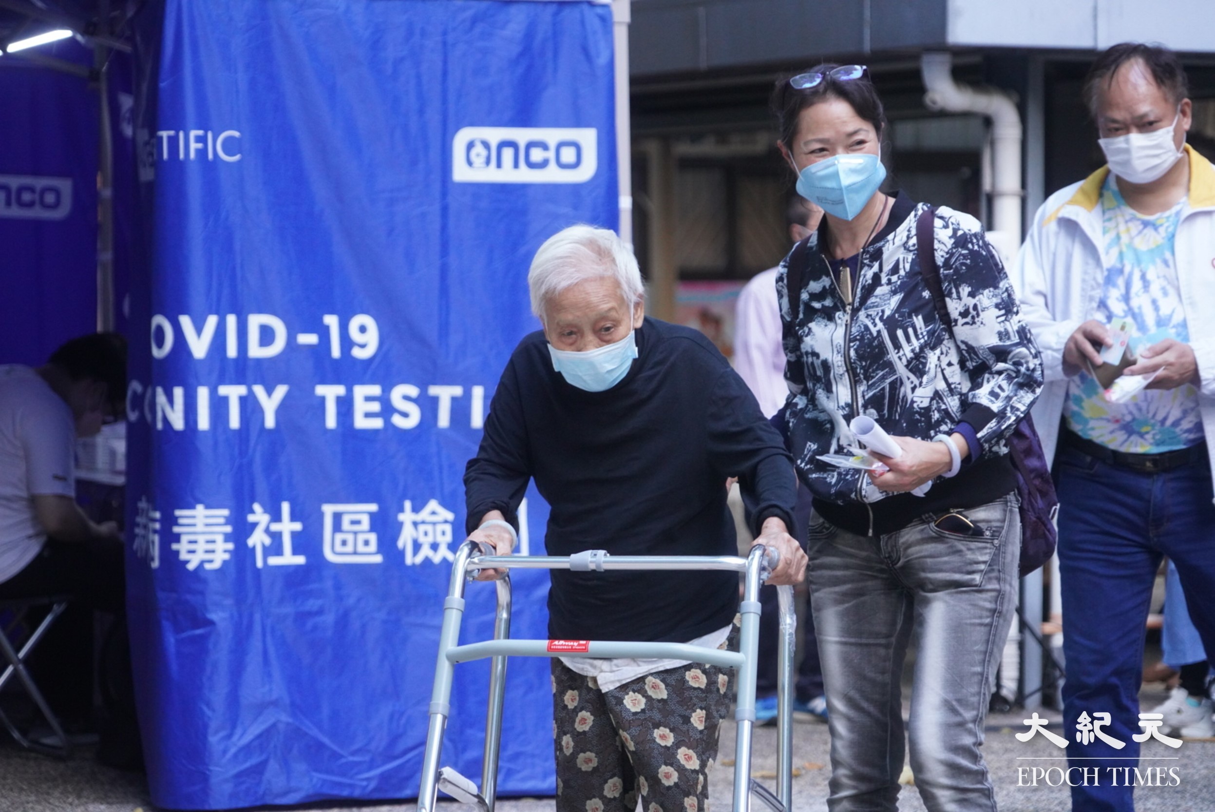 因驗到污水呈陽性，深水埗白田邨澤田樓圍封強檢，住戶收到通知下樓做核酸檢測，有行動不便老人需由親人陪同。（余鋼／大紀元）