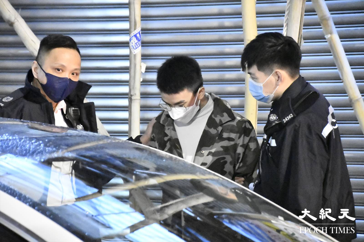 西九龍衝鋒隊於旺角設置路障期間，拘捕一名20餘歲涉嫌販毒男子（穿迷彩外套），疑犯被押返涉案私家車旁協助搜證。（麥碧／大紀元）