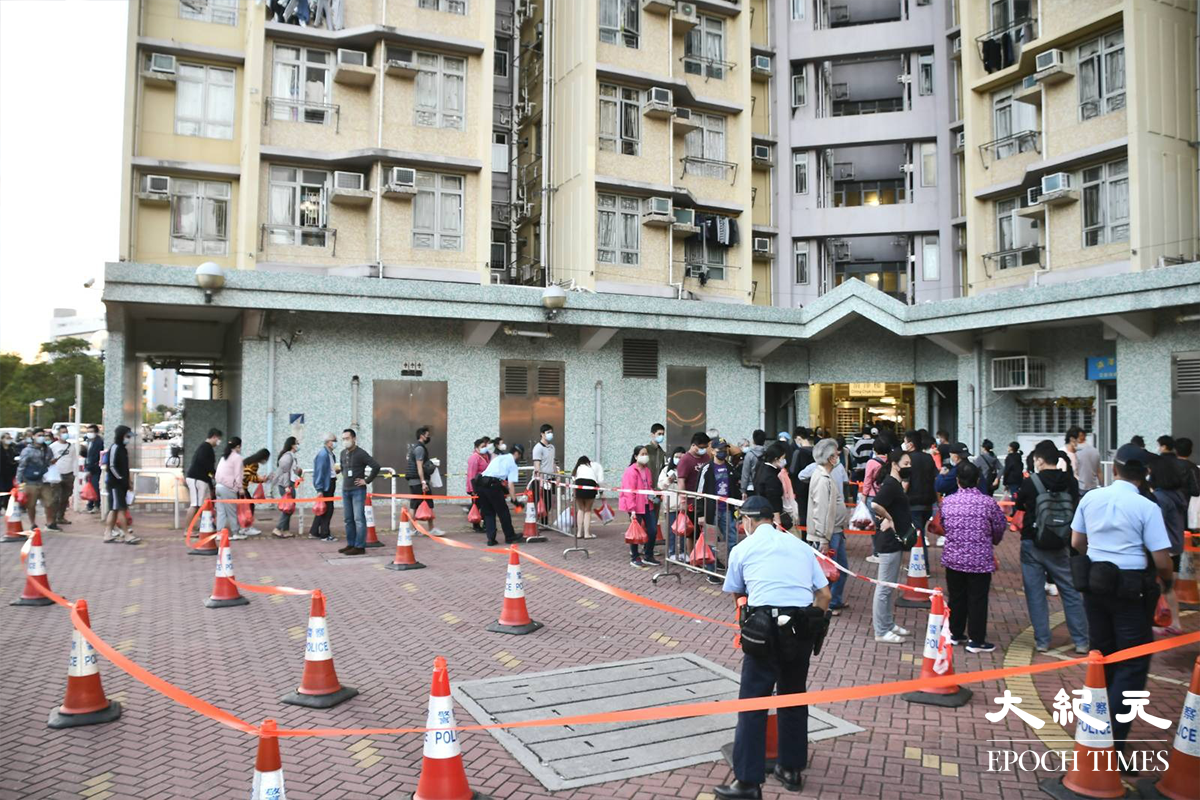 傍晚6時許，約30多名清澤樓住戶領取物資包後在大廈外排隊，等候返回家中。（麥碧／大紀元）