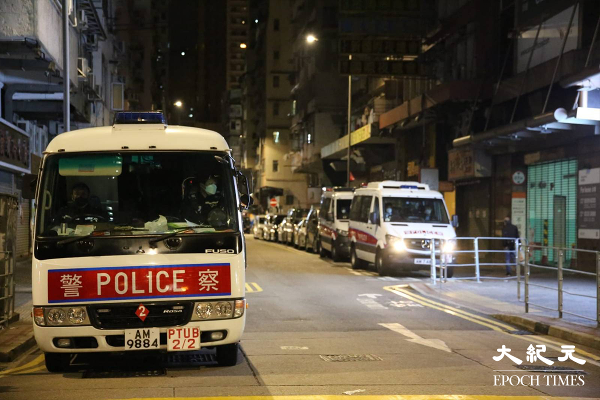 警方凌晨接報，有市民於油麻地砵蘭街109號至113號偉華大廈一單位內遭非法禁錮及被斬傷，隨即派出大批警員趕至。（卓相如／大紀元）