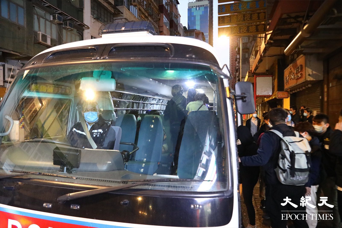 接近清晨時分，警方將被捕的46人，分批帶上警車押返警署扣查。（李辰／大紀元）