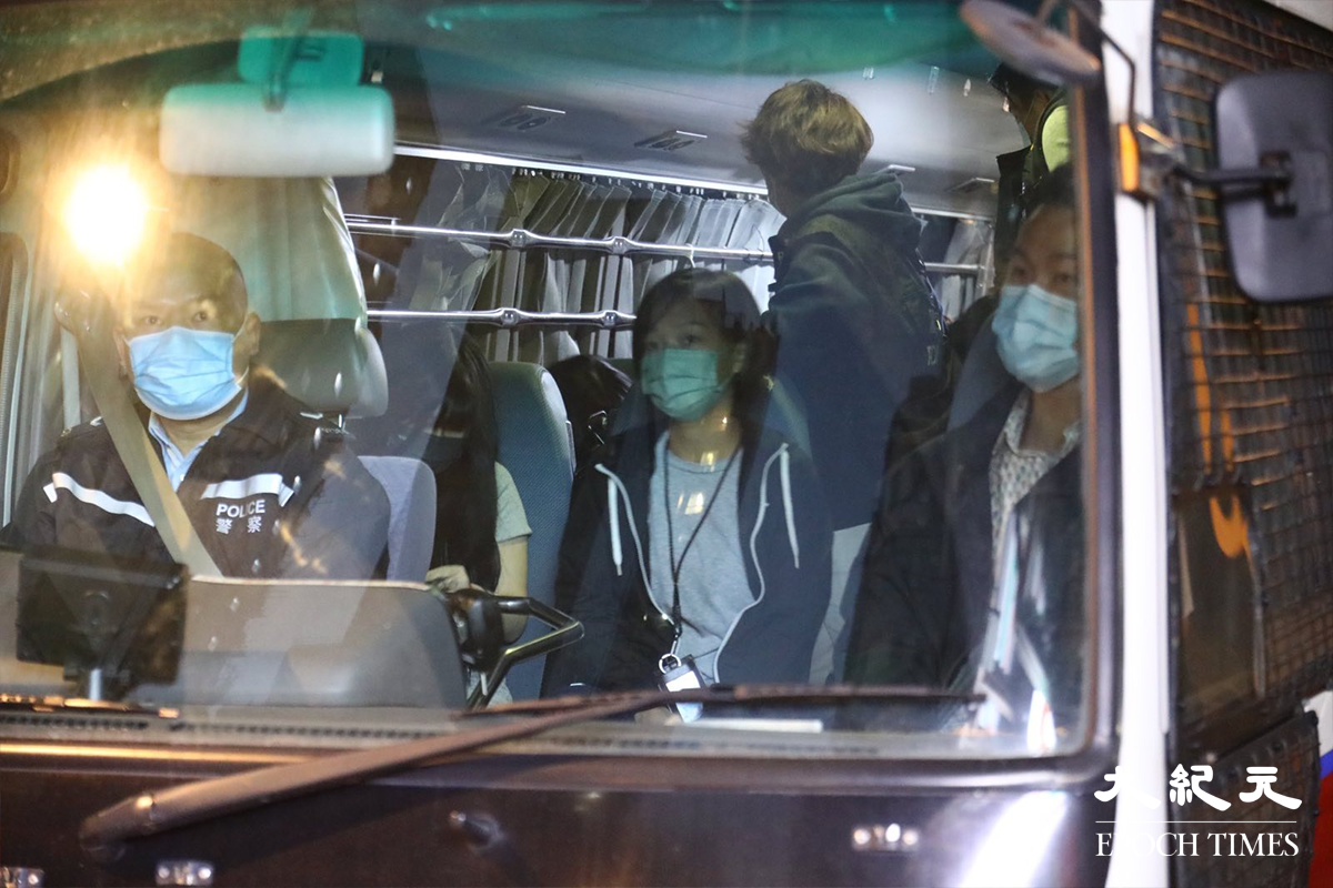 接近清晨時分，警方將被捕的46人分批帶上警車，押返警署扣查。（李辰／大紀元）