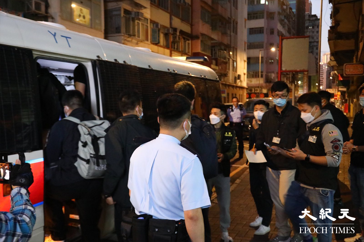 接近清晨時分，警方將被捕的46人分批帶上警車，押返警署扣查。（李辰／大紀元）