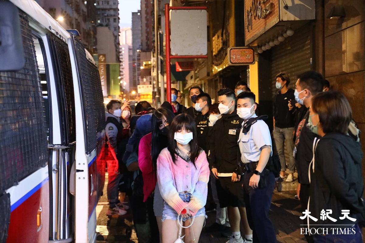接近清晨時分，警方將被捕的46人，分批帶上警車押返警署扣查。（李辰／大紀元）