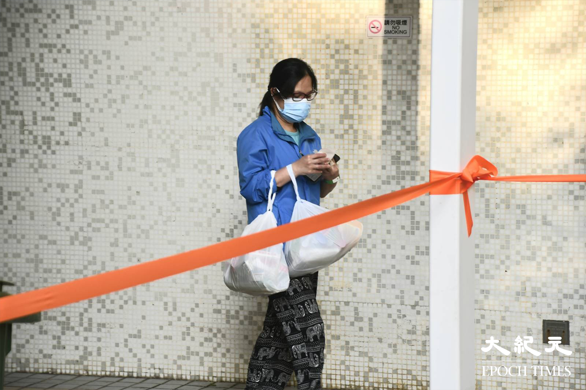 宏景花園第三座住戶，完成強制檢測及領取物資包後，正在返回家中。（麥碧／大紀元）