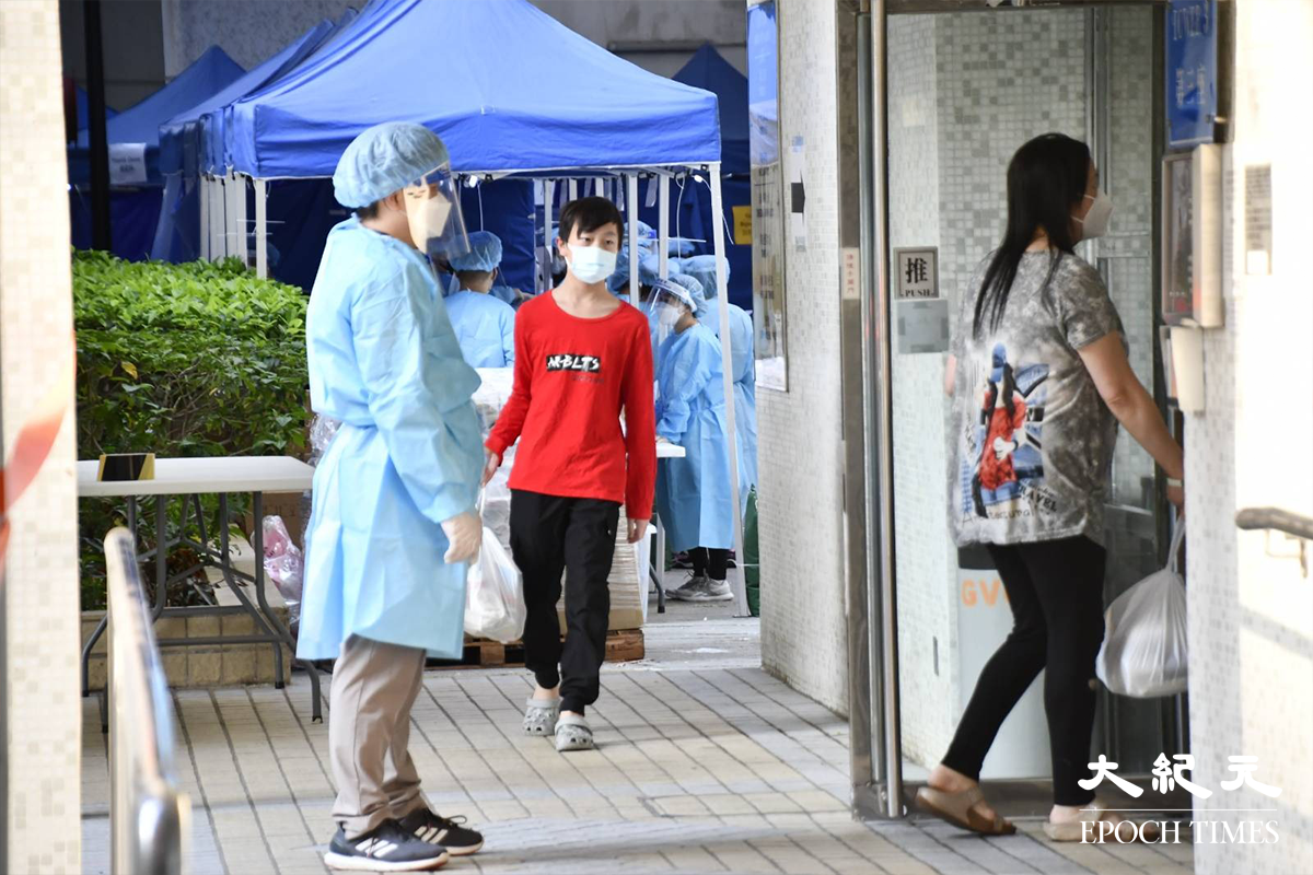 宏景花園第三座住戶，完成強制檢測及領取物資包後，正在返回家中。（麥碧／大紀元）